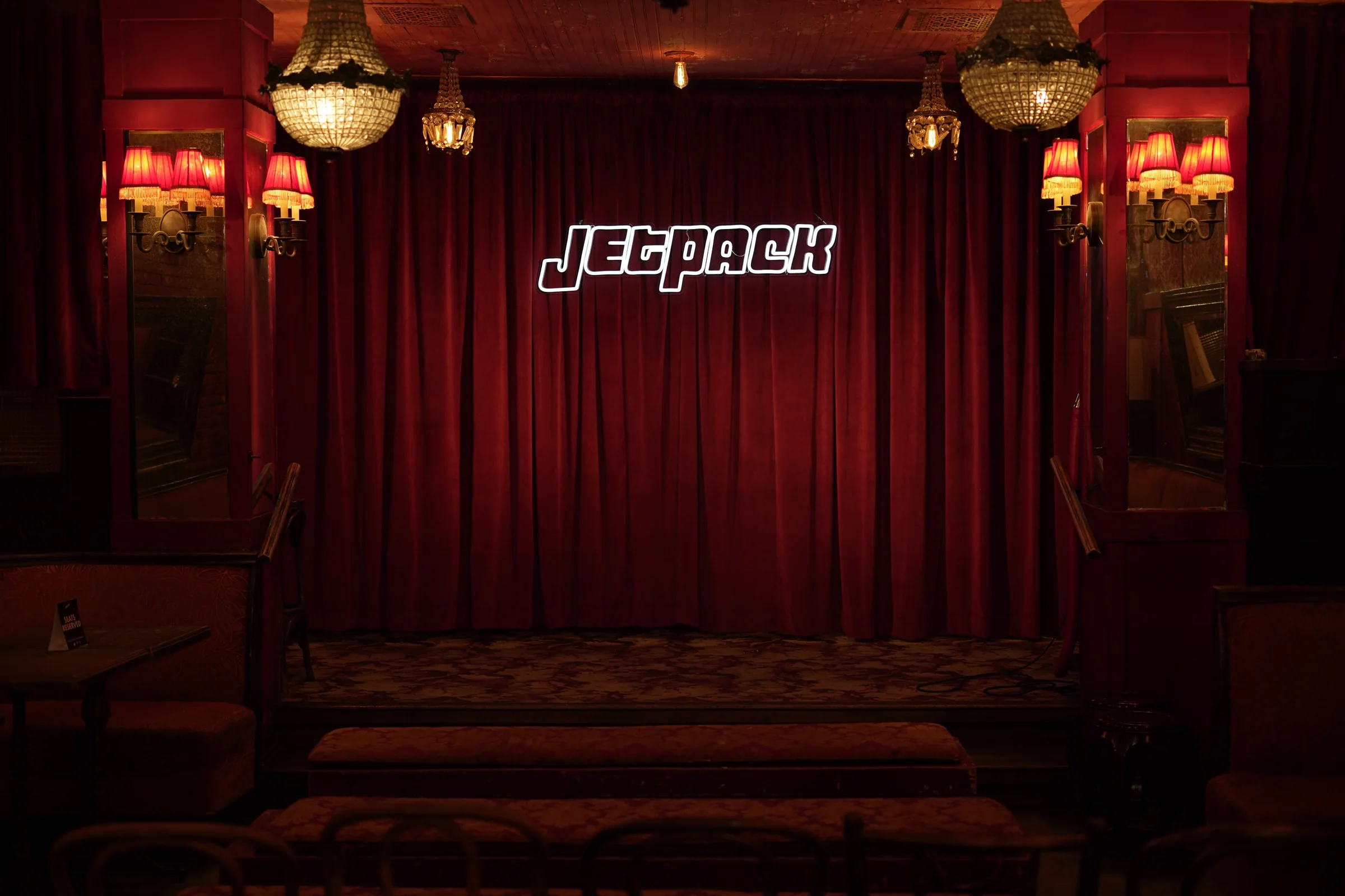 The showroom at Bar Lubitsch: red velvet, chandeliers and the Jetpack neon